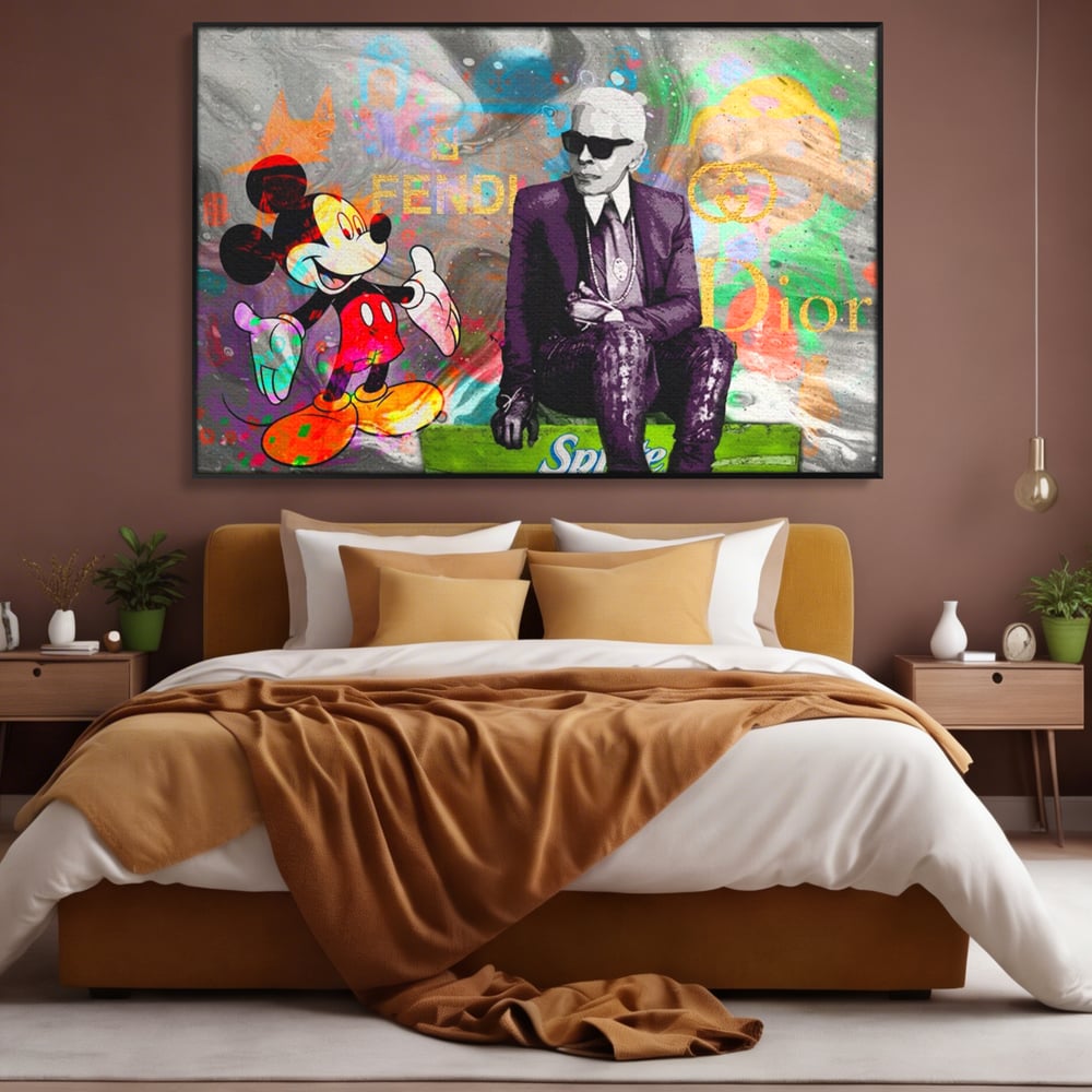 Tablou canvas cu tablou canvas cu mickey mouse si karl lagerfeld, in rama de aluminiu negru, pe perete intr-un dormitor